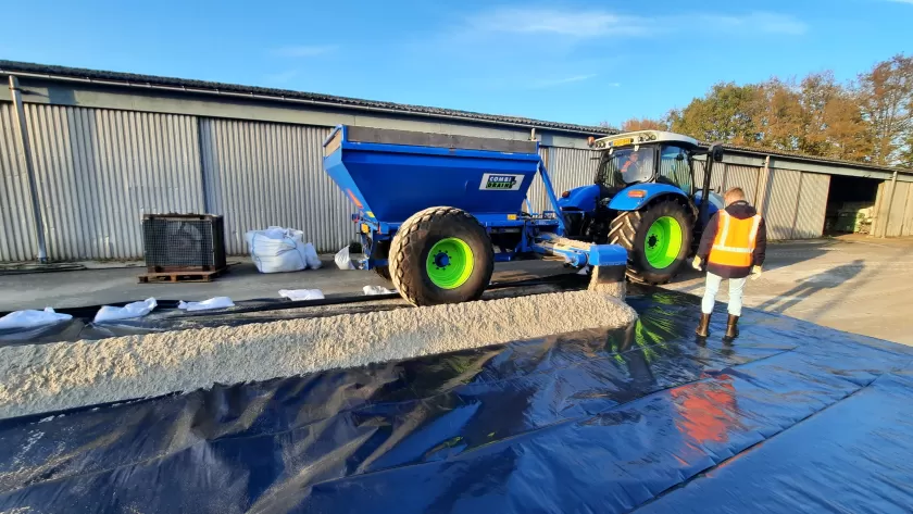 Strook zand d.m.v. zandkar op folie plaatsen